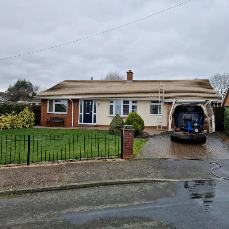 Tiled roof surface being cleaned of moss and algae